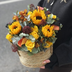 Композиция в сумке "Тональность" из подсолнухов, калл, ягод вибирнума, лимонных роз, скиммии и орхидеи в Пушкино